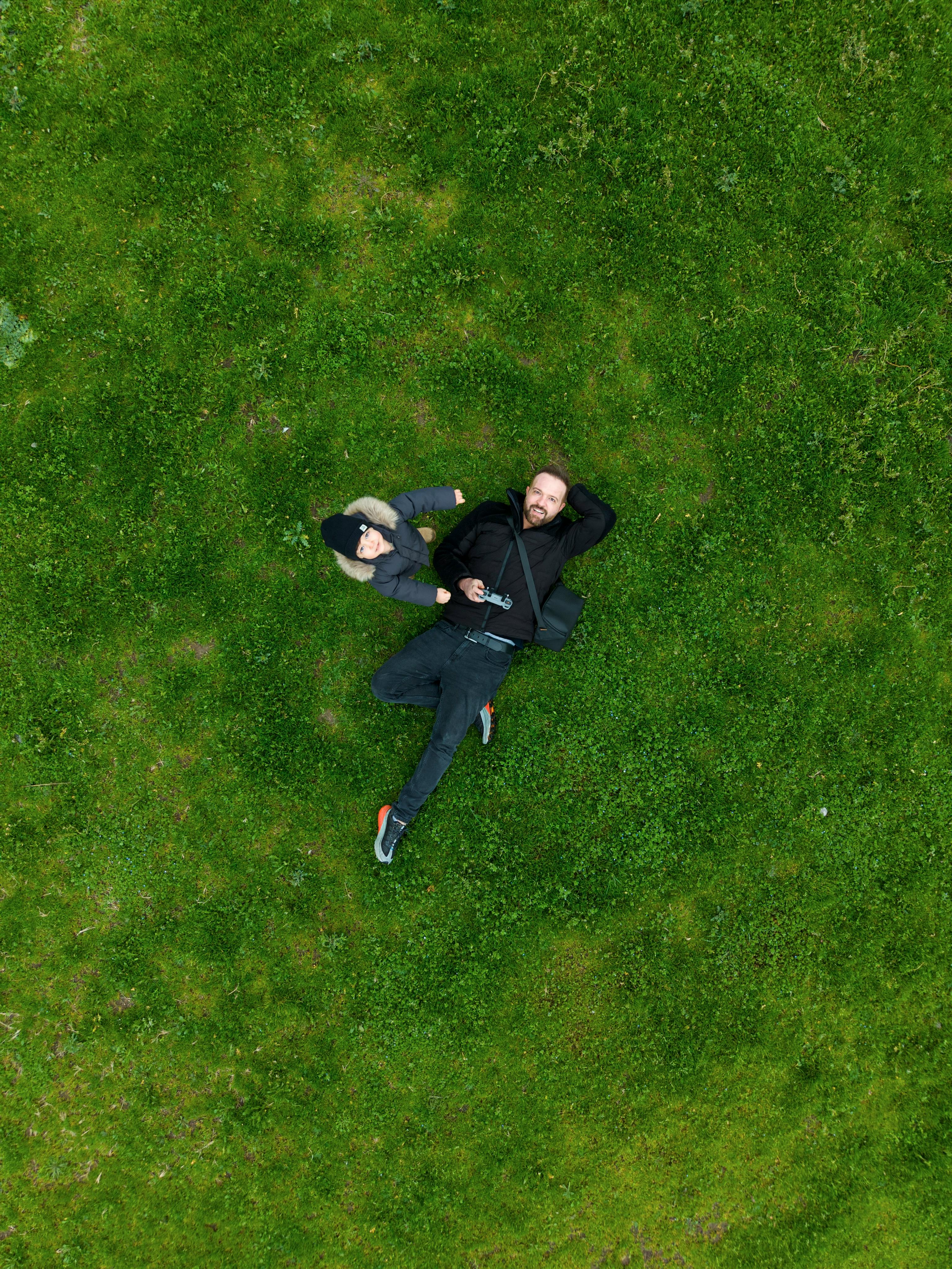 Δωρεάν Αεροφωτογραφία δύο ατόμων που χαλαρώνουν σε καταπράσινο γρασίδι, απαθανατίζοντας μια γαλήνια στιγμή σε εξωτερικό χώρο στην Προύσα της Τουρκίας. Φωτογραφία από στοκ φωτογραφιών