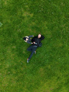 Aerial view of two people relaxing on lush green grass, capturing a serene outdoor moment in Bursa, Türkiye.