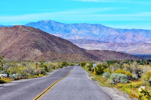 Free Desert road leading to scenic mountain range in San Diego, California. Stock Photo
