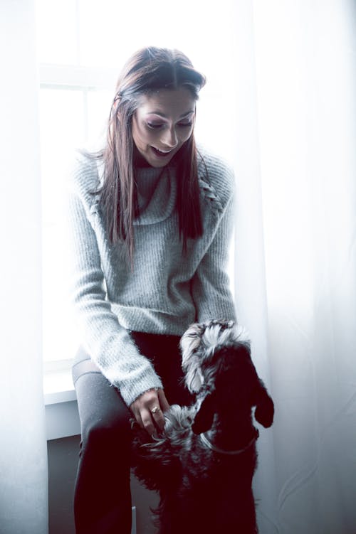 Free Woman in Gray Sweater with a black dog Stock Photo