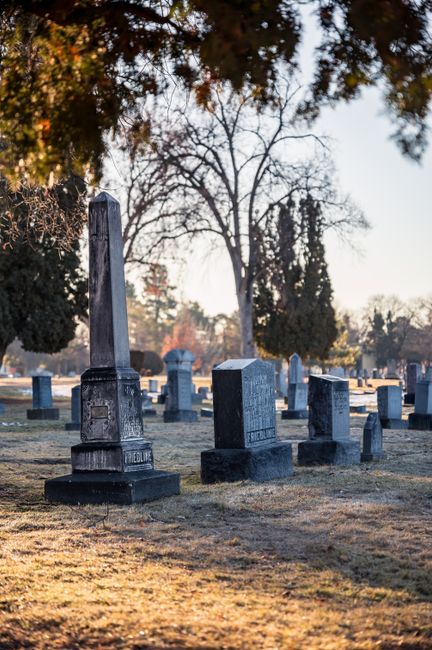 Fotomural Una vista serena de un antiguo cementerio con varias tumbas bajo un cielo despejado.