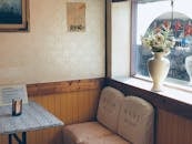 复古咖啡馆的温暖角落里，有座位、阳光和窗前的花瓶