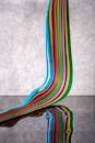 Vibrant Multicolored Ribbon Drop on Reflective Surface