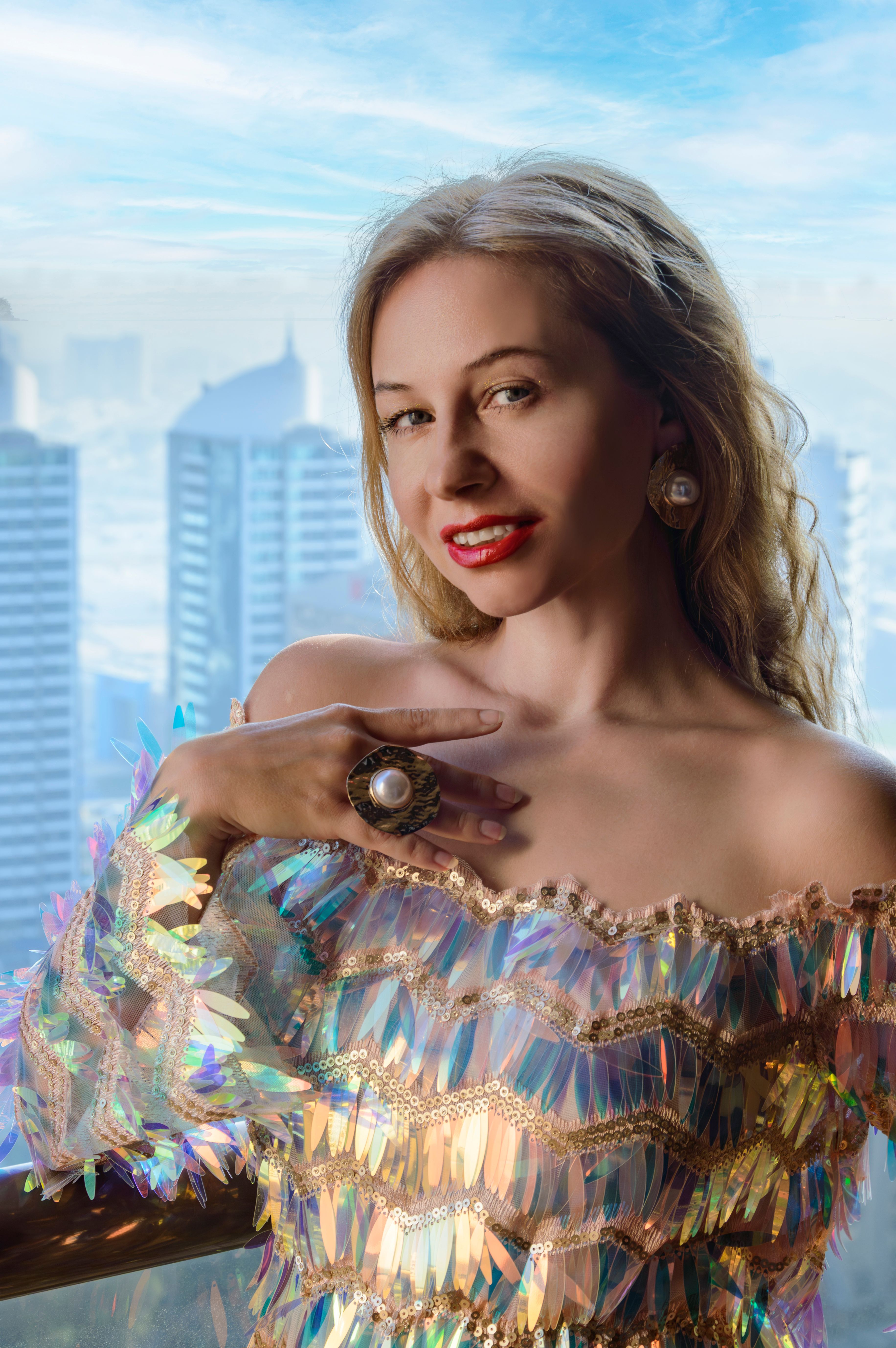 Elegant woman wearing shimmering outfit with urban skyline background. Fashion and luxury concept.