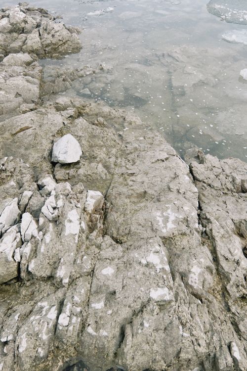 Free Natural rocky shoreline at the edge of a calm lake in Konaev, Kazakhstan. Stock Photo