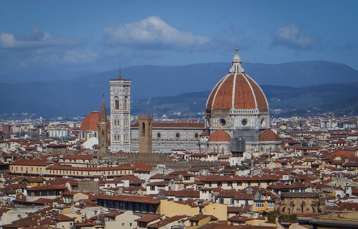 Panoramic view of Florence cityscape from above showing terracotta rooftops Arno river and Tuscan hills