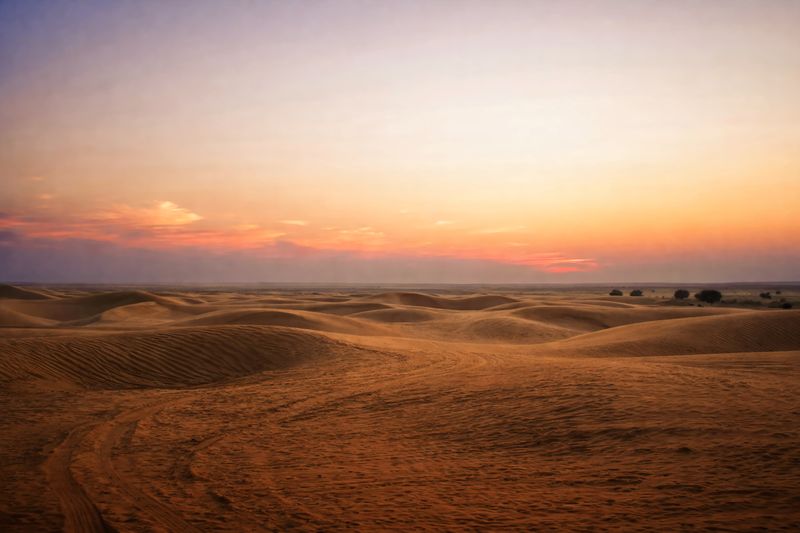 Wide sand dunes under a glowing sunset sky in Jaisalmer
