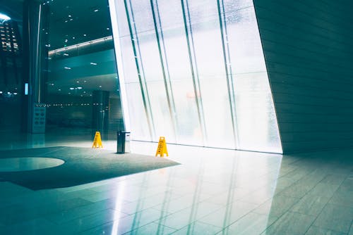 Yellow Wet Floor Signages Near Glass Wall