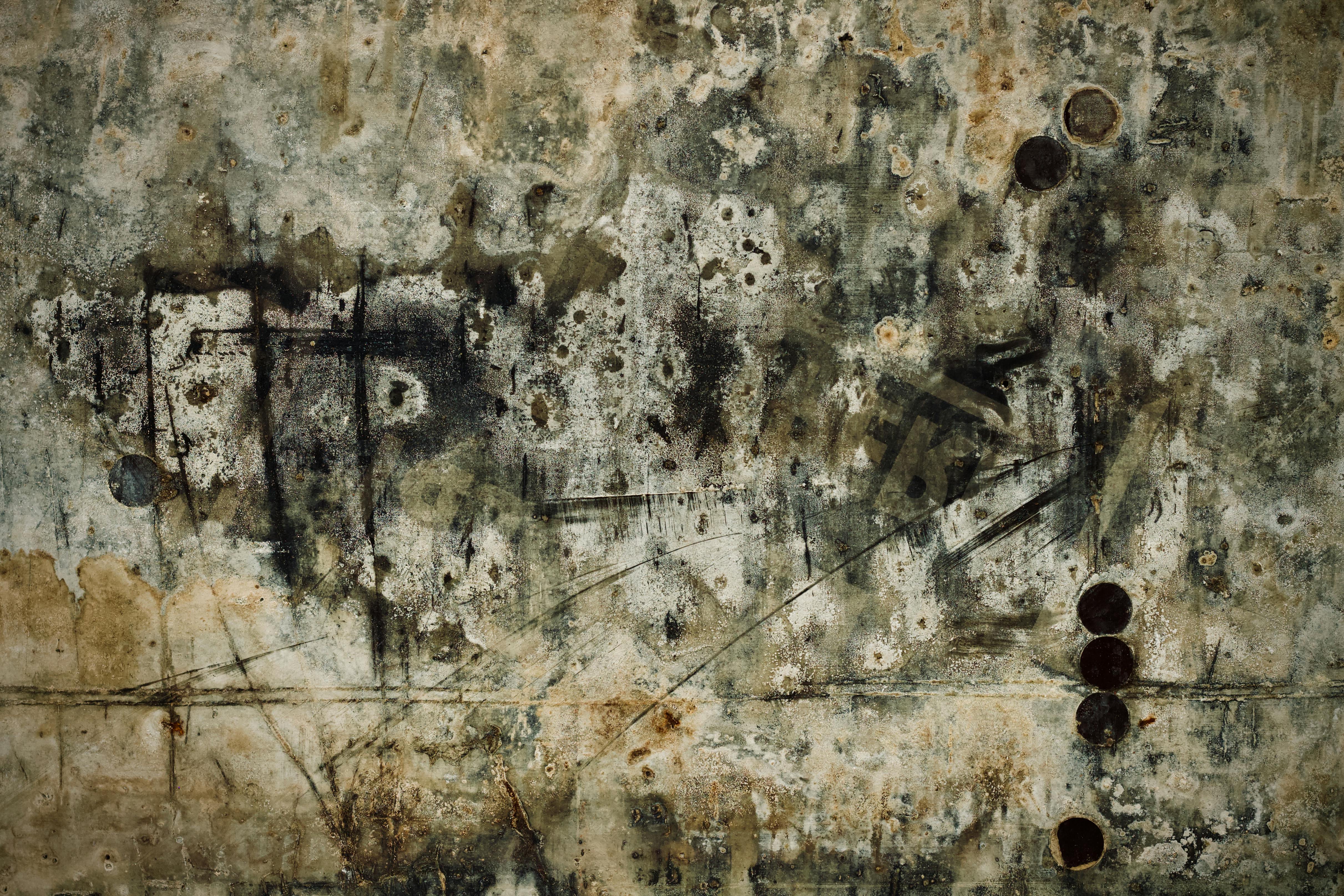 gratis Een gedetailleerde abstracte textuur van een verweerde, vuile muur met vlekken en roestplekken. Stockfoto