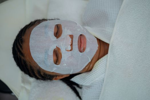 Woman enjoying a rejuvenating facial mask treatment at a spa in Abuja, Nigeria.