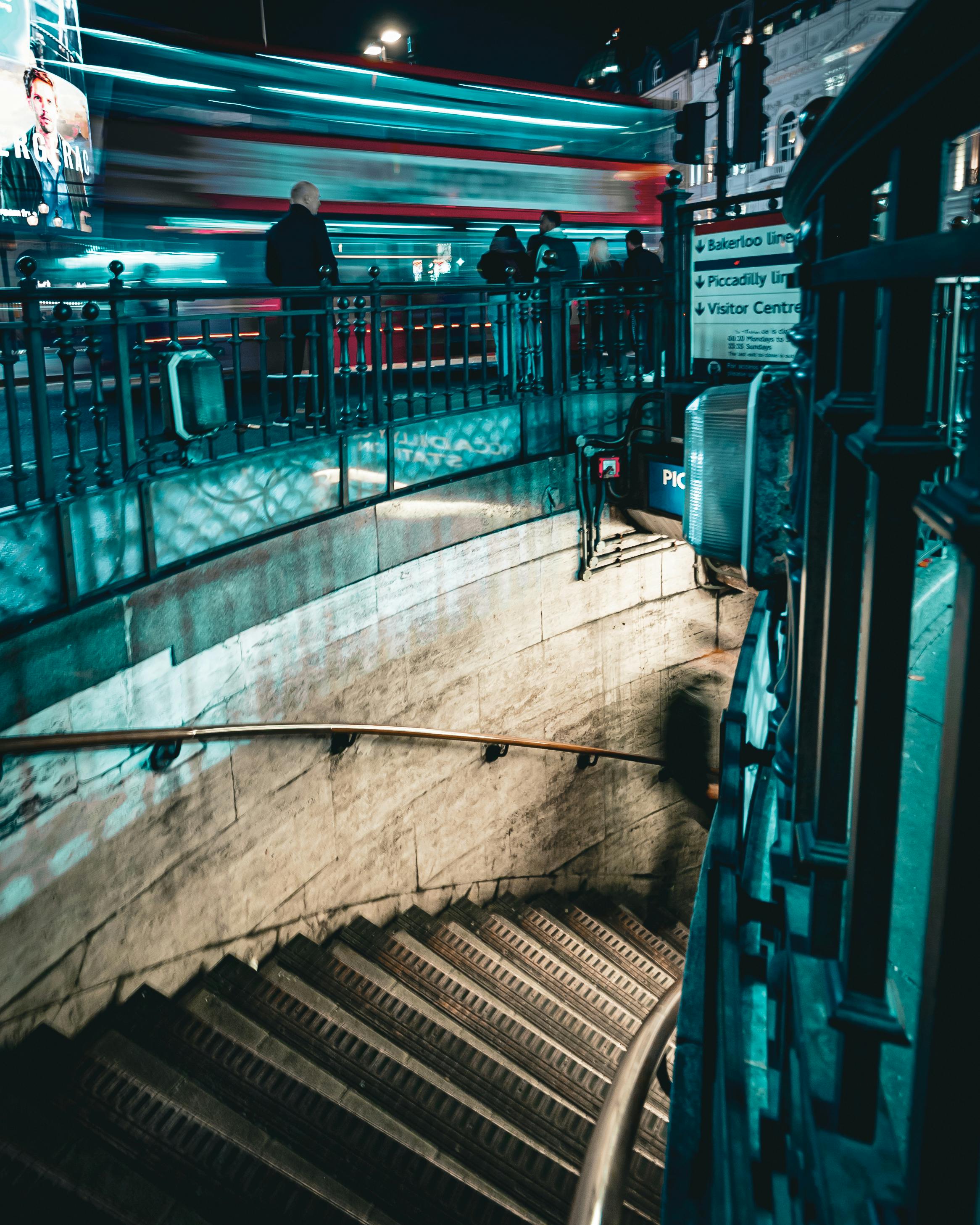 gratis Levendige nachtscène op Piccadilly Circus, met bewegingsonscherpte van een voorbijrijdende bus en een verlichte ingang van de metro. Stockfoto