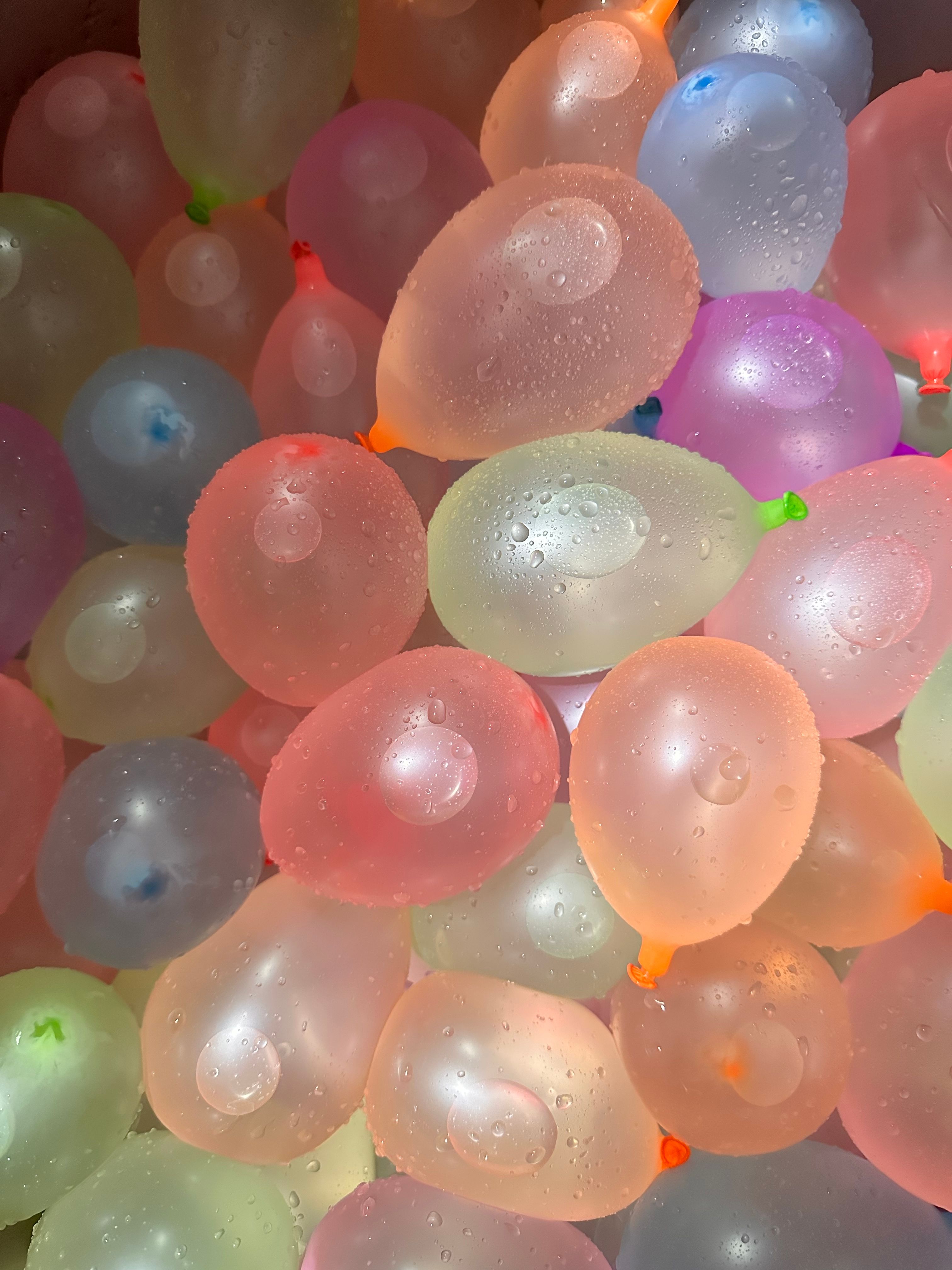 Vibrant water balloons captured close-up with droplets, perfect for summertime fun.