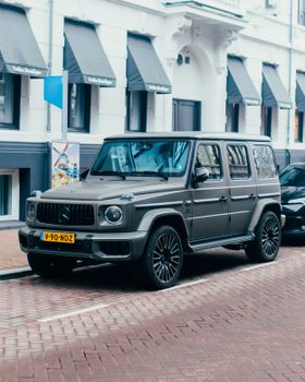 A sleek grey SUV parked on a cobblestone street in a European city, showcasing urban luxury and style.