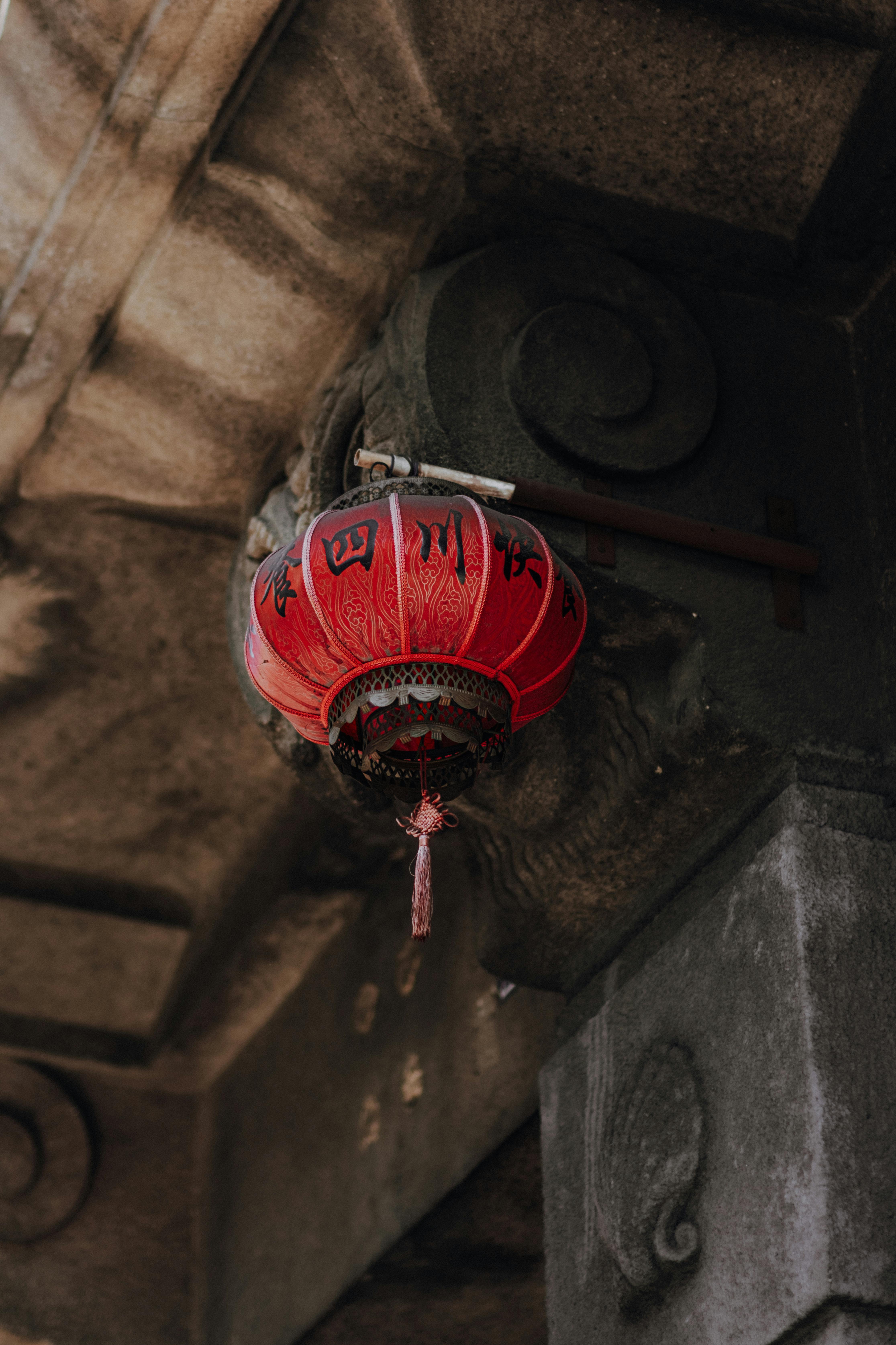 gratis Een gedetailleerde rode lantaarn met Chinese karakters onder een stenen boog. Stockfoto