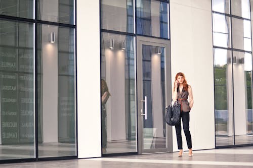 Free stock photo of attractive, building, business woman on the phone