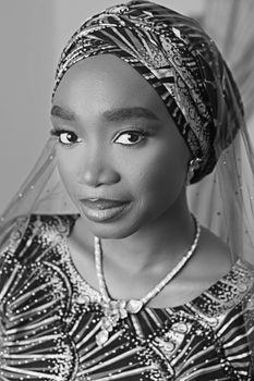 Stylish black and white portrait of a woman wearing traditional attire with intricate patterns.