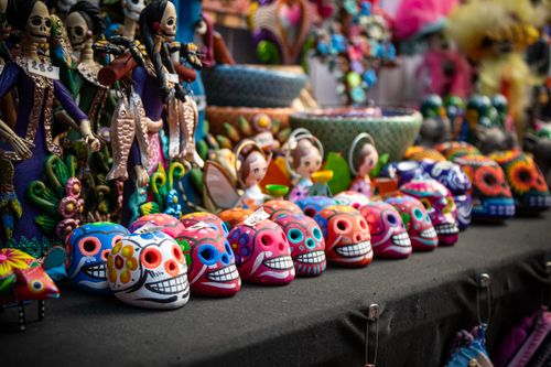 Free Colorful Mexican skulls and figures showcase traditional Day of the Dead art in vibrant hues. Stock Photo