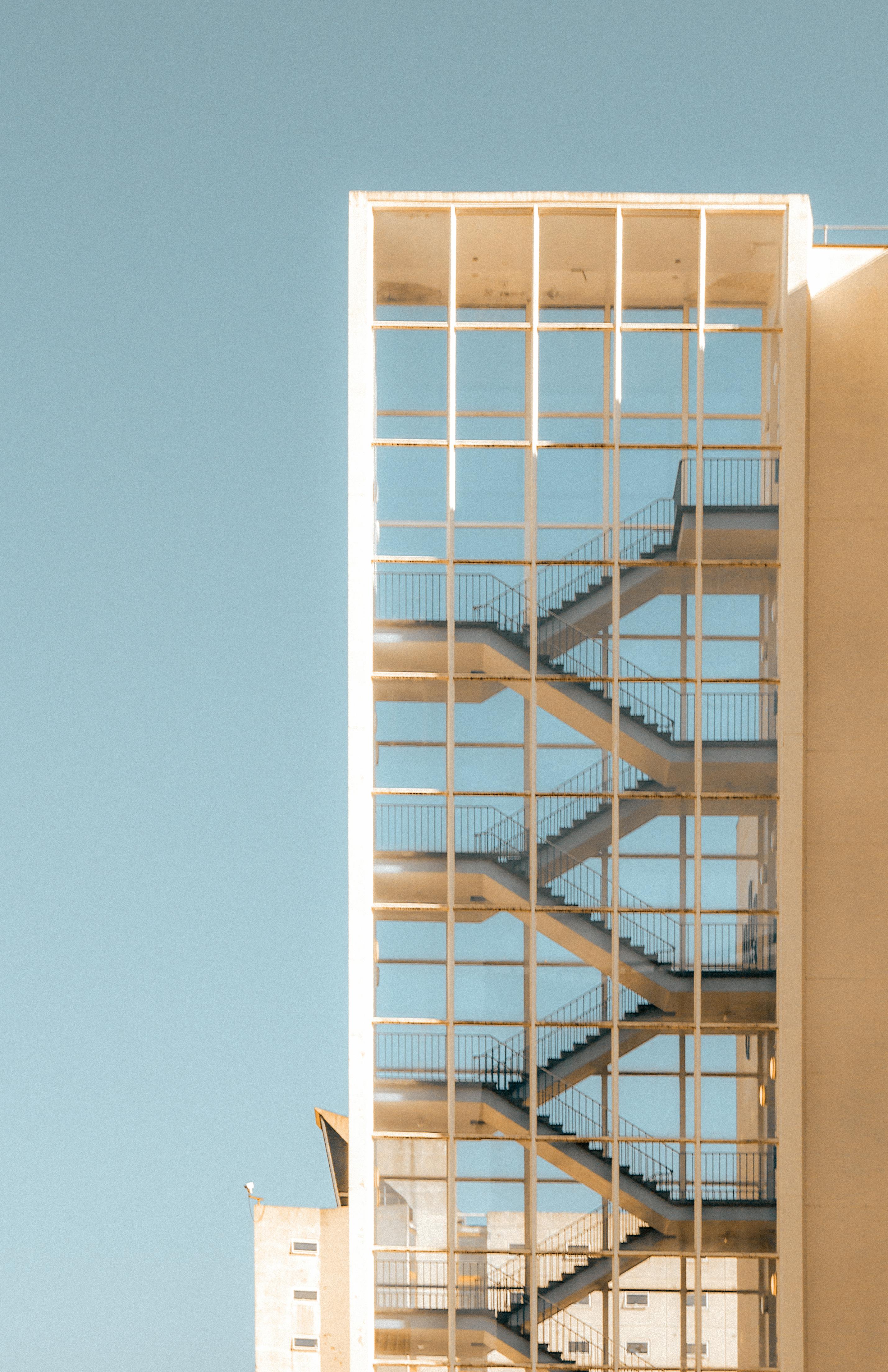 Gratis Una moderna escalera de cristal en Manchester contra un cielo azul claro. Foto de stock
