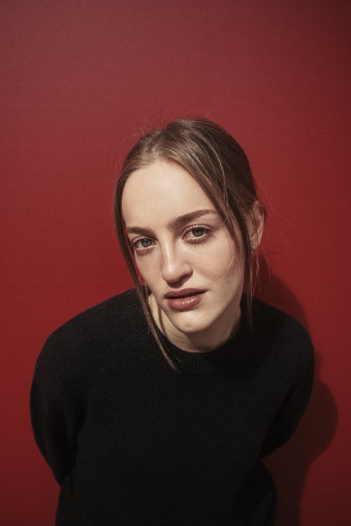 Free Stylish portrait of a woman in black against a vivid red wall. Stock Photo