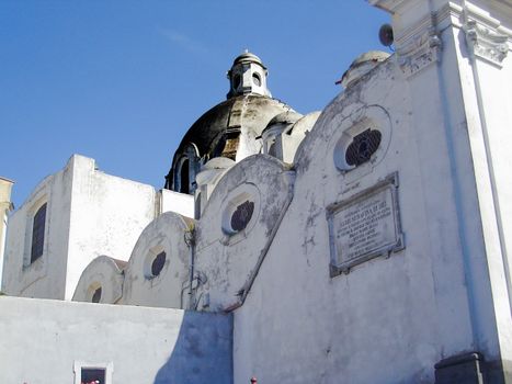 White-washed historic church under a clear blue sky, showcasing classical architecture.