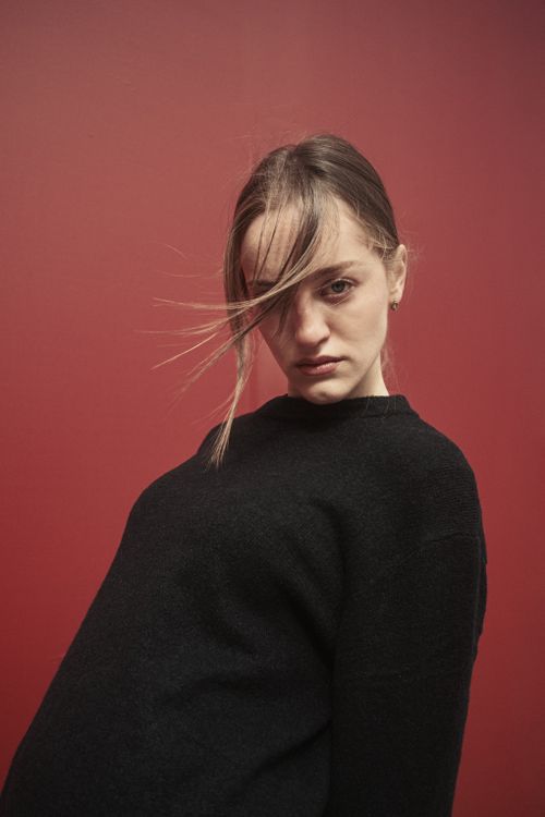 Free Artistic close-up portrait of a woman against a red backdrop, focusing on style and attitude. Stock Photo