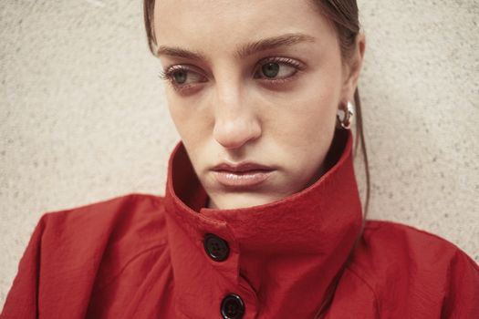 A close-up shot of a woman in a red coat against a textured background in Istanbul.