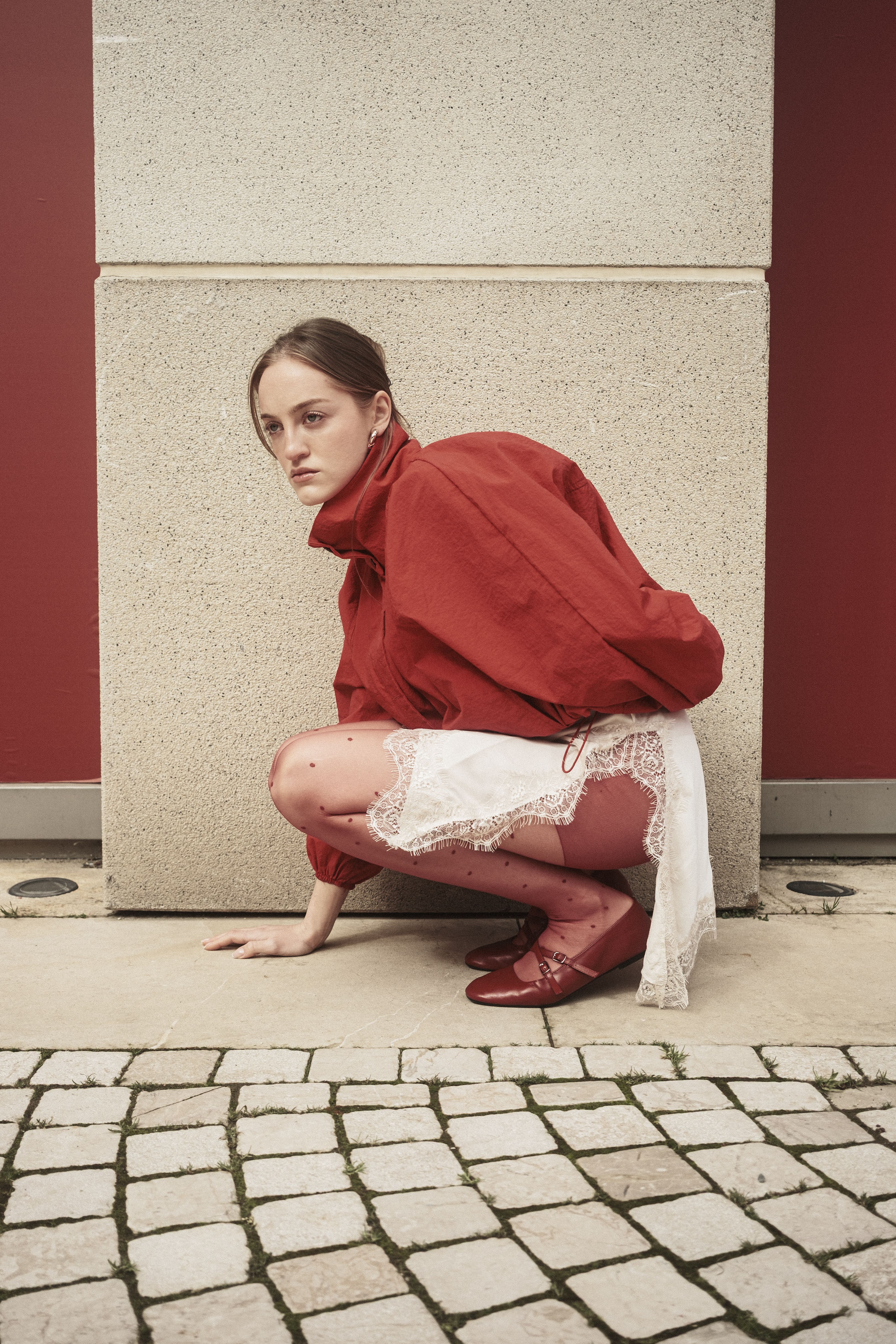 Fashionable model posing in a red outfit against a neutral backdrop in Istanbul.