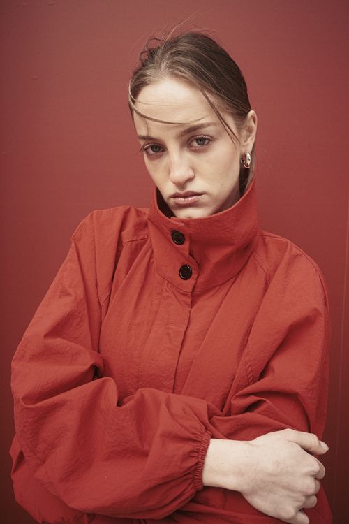 Free Elegant portrait of a woman in a red jacket against a matching background Stock Photo