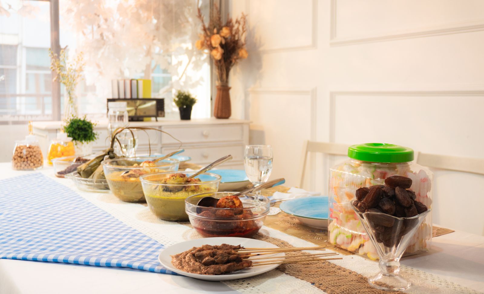 A bright indoor dining table set with various dishes ready for a festive meal.