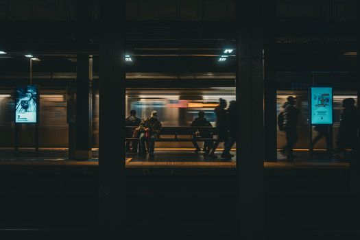 Blurred motion of subway at New York City station capturing urban nightlife.