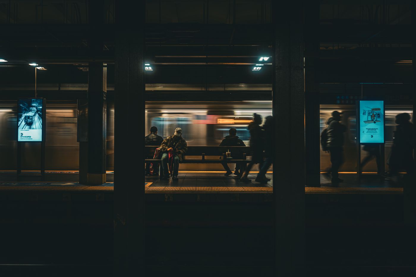 Commuters on a night platform as a train pulls in — photo by Brent Singleton on Pexels