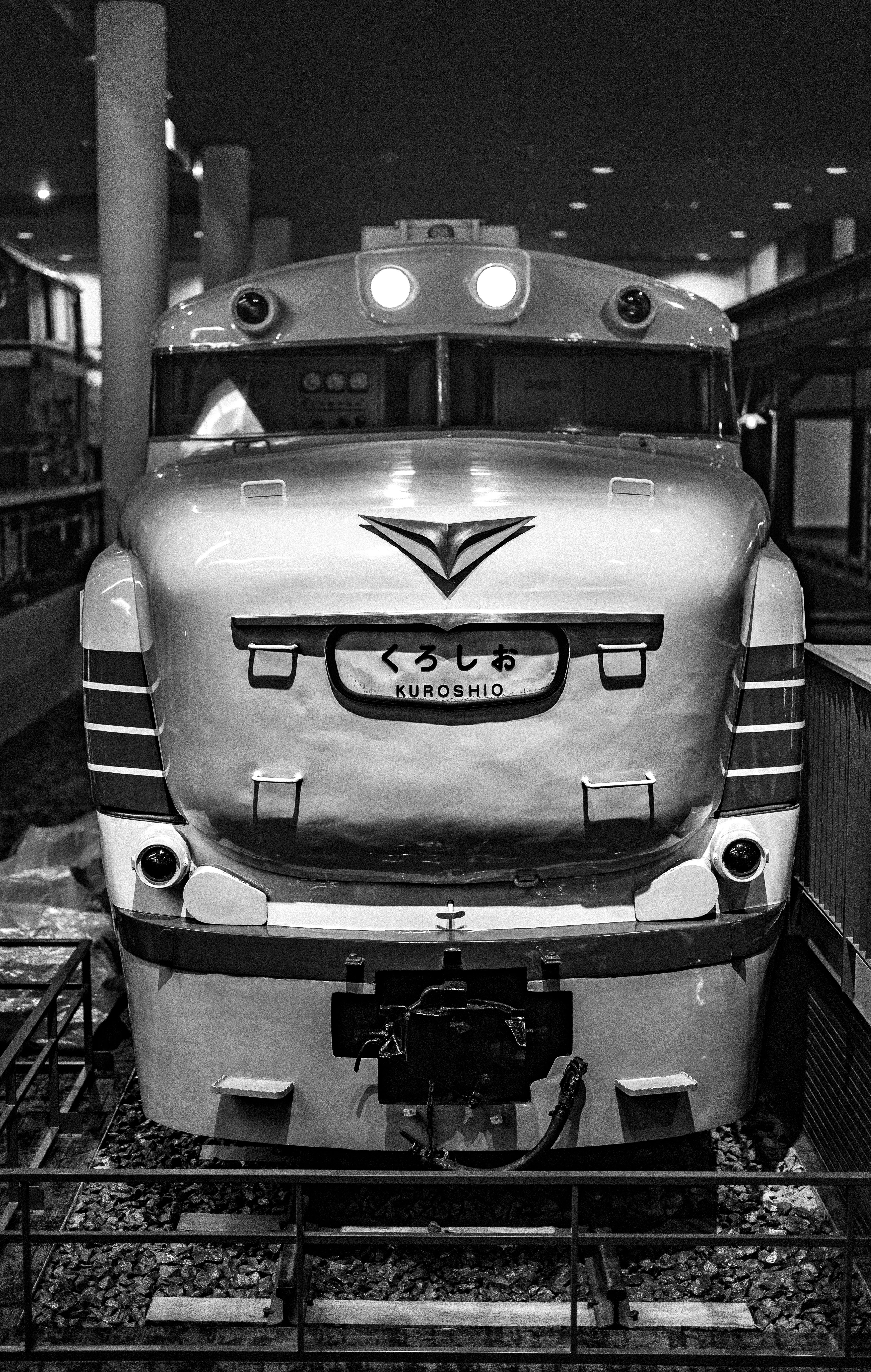 Black and white photo of a vintage Kuroshio train in a museum setting.