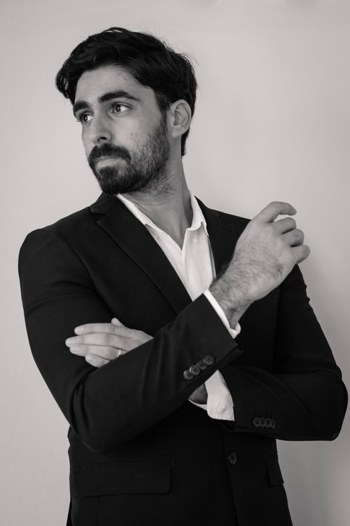 Free Black and white portrait of a man in a suit gazing thoughtfully to the side, showcasing professional elegance. Stock Photo
