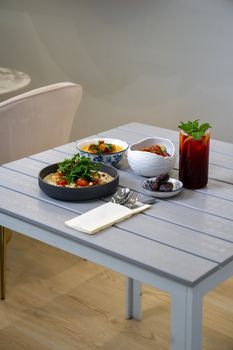 A beautifully set table with various dishes including hummus and a refreshing drink.