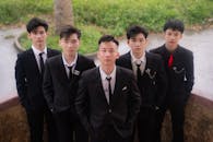 Five Young Men in Suits Posing Outdoors