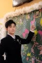 Young man in formal attire pointing at colorful board