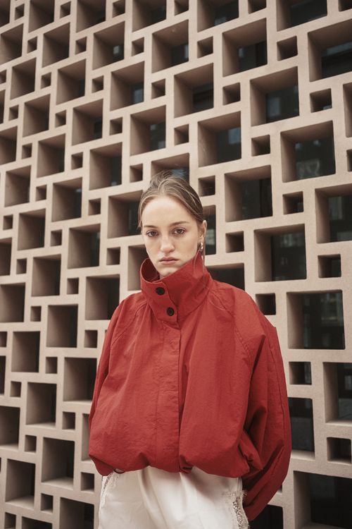 Free Stylish woman in red outfit posed by modern geometric wall in Istanbul. Stock Photo