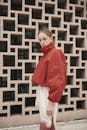 Fashionable Woman in Red Jacket against Geometric Wall