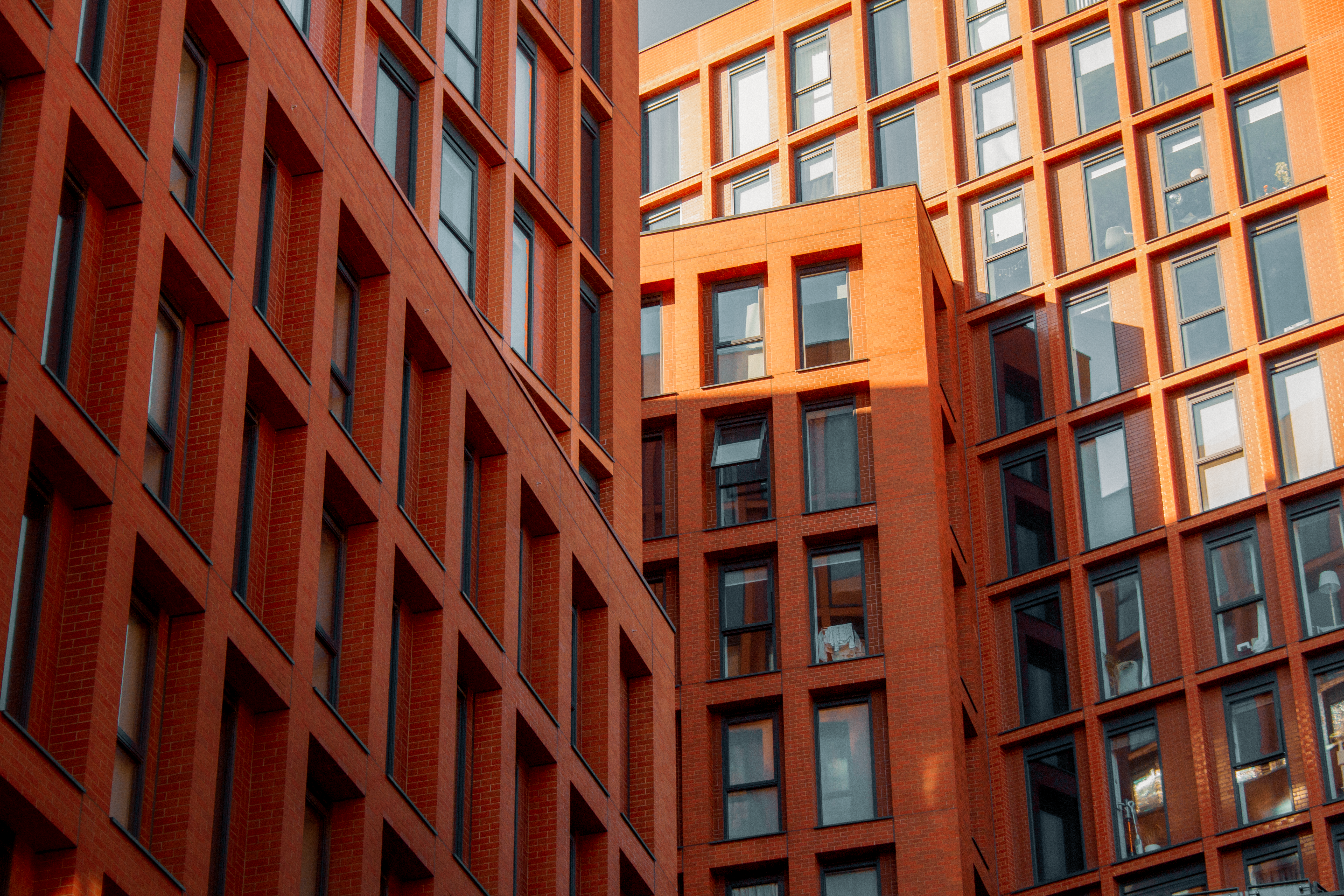 Captivating sunlit view of modern brick architecture in Manchester, UK, showcasing intersecting patterns and urban design.