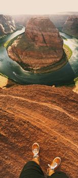 Breathtaking aerial view of Horseshoe Bend with a person standing on the cliff edge.