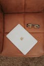 Sleek Laptop and Glasses on Leather Chair