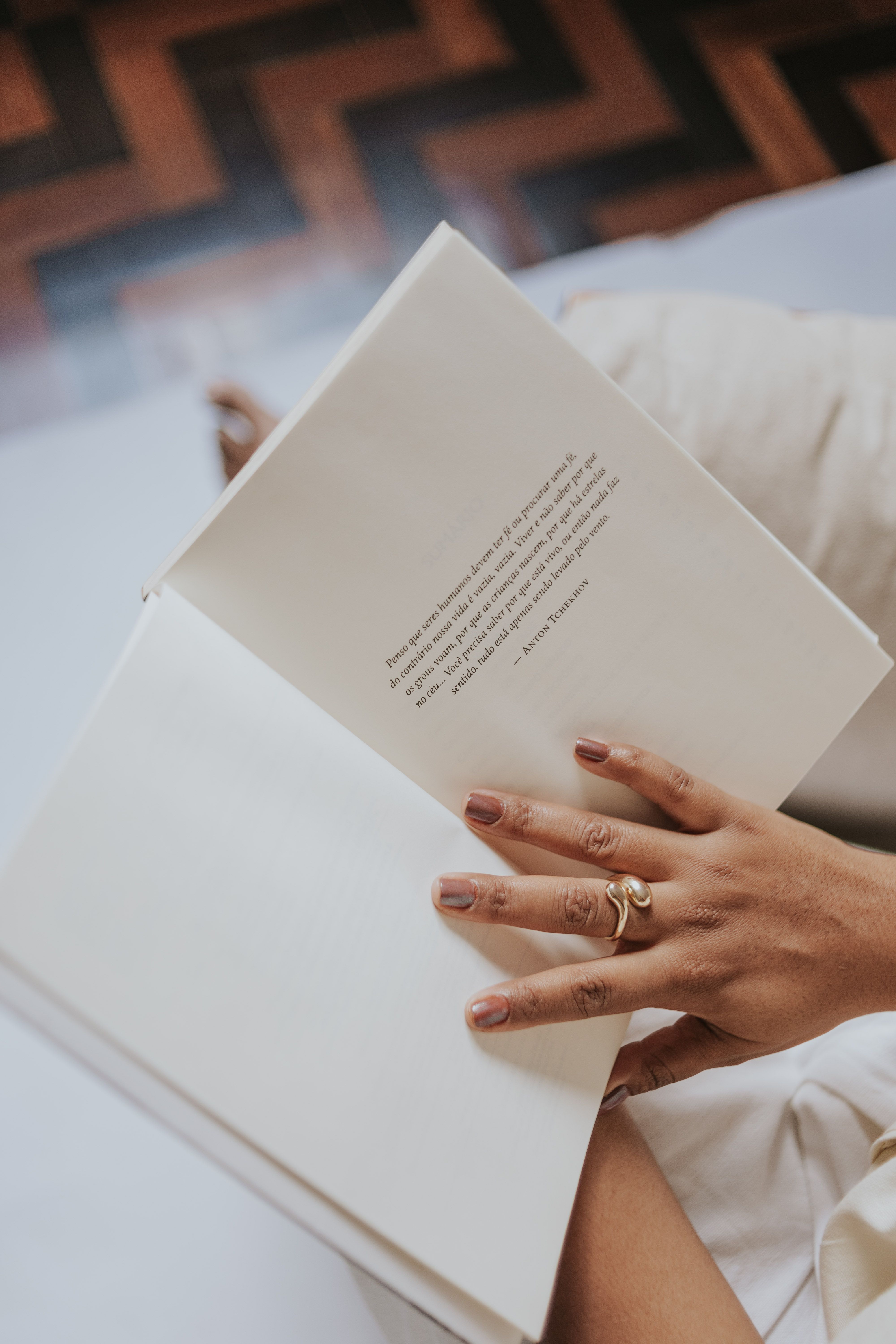 A cozy scene of a person enjoying a quiet moment reading an open book indoors.