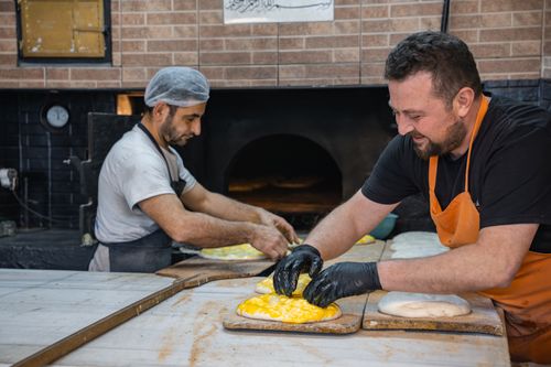 Free Two artisans skillfully prepare dough in a traditional bakery, capturing cultural culinary arts. Stock Photo