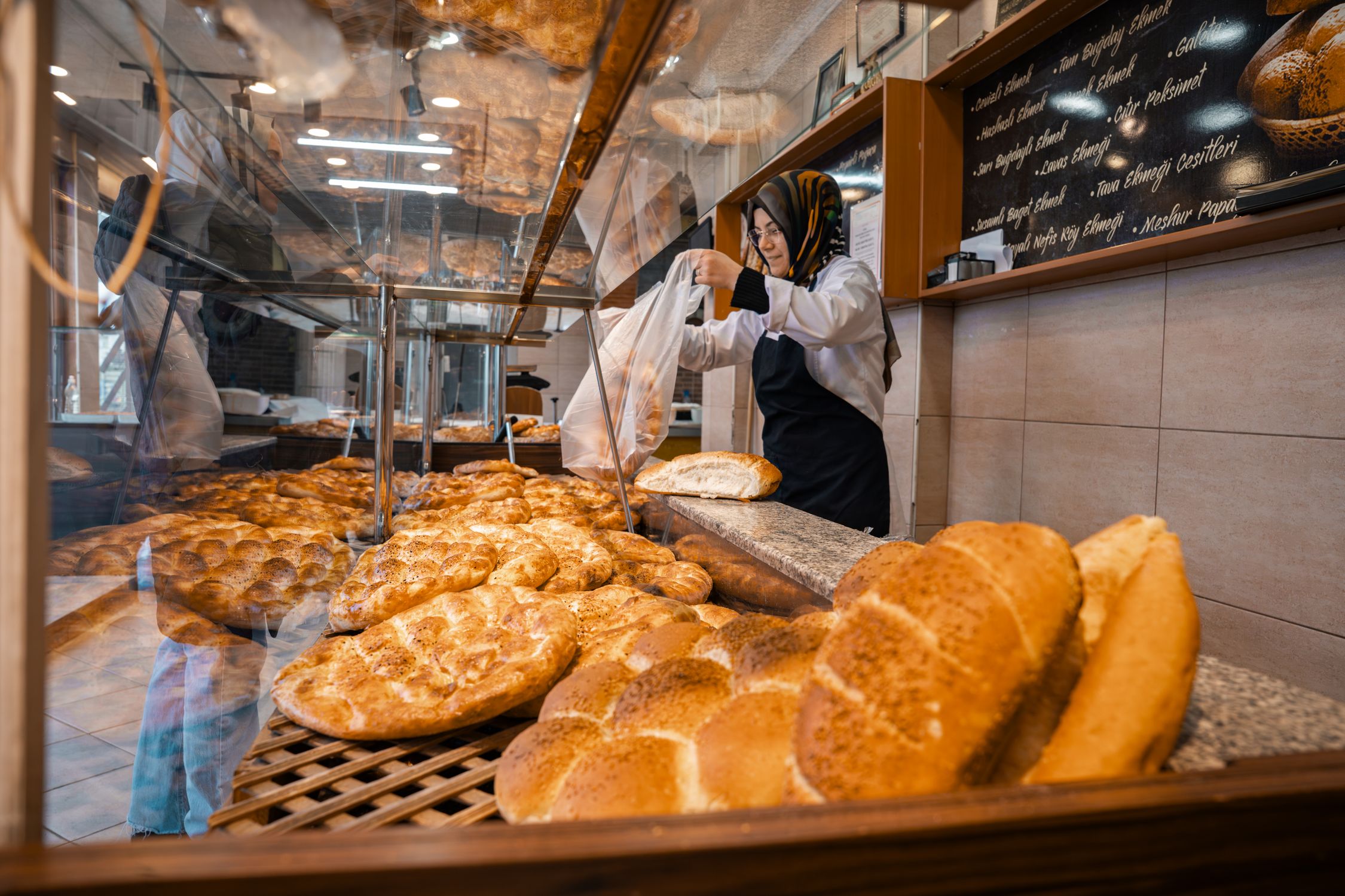 Bakery Display with Fresh Bread and Baker · Free Stock Photo