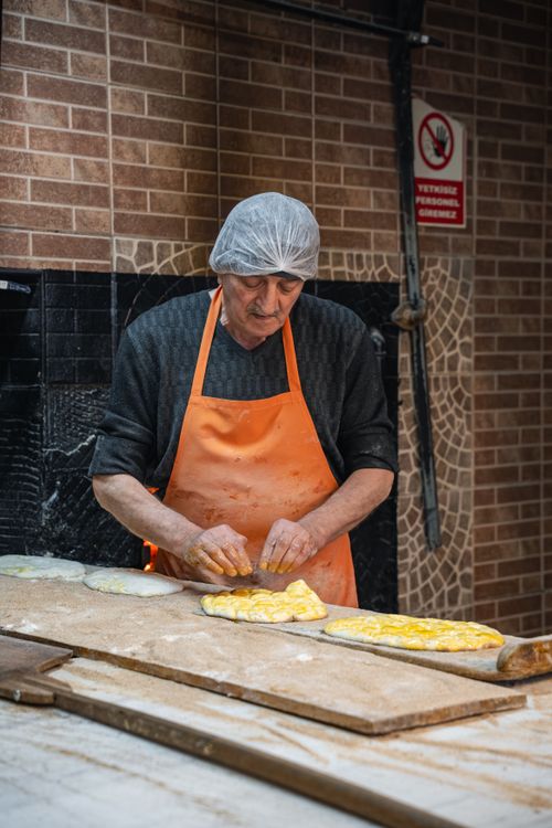 Free A seasoned baker works dough in a rustic kitchen setting, showcasing traditional techniques. Stock Photo