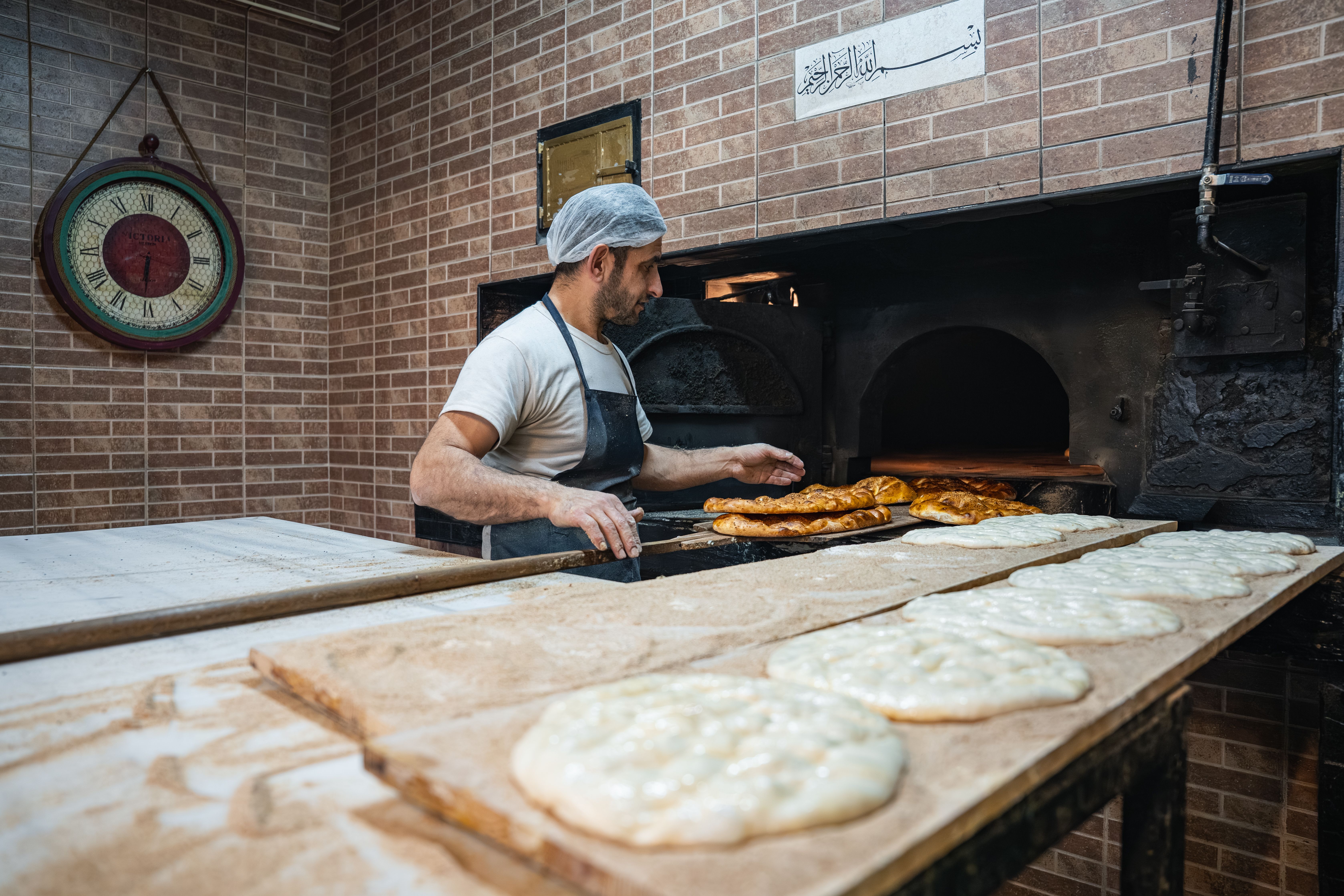 Artisan Baker Preparing Bread in Traditional Oven · Free Stock Photo