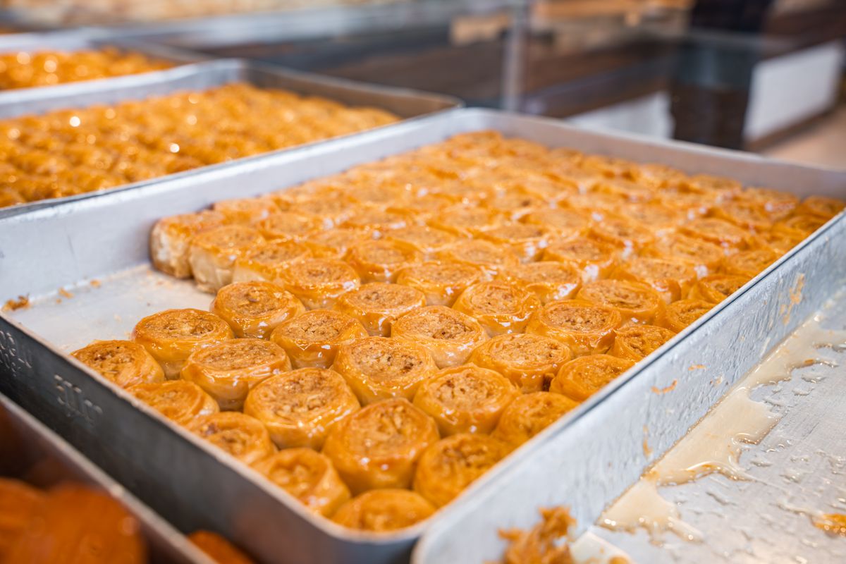 Delicious freshly baked sweet pastries in trays displayed in a bakery setting.