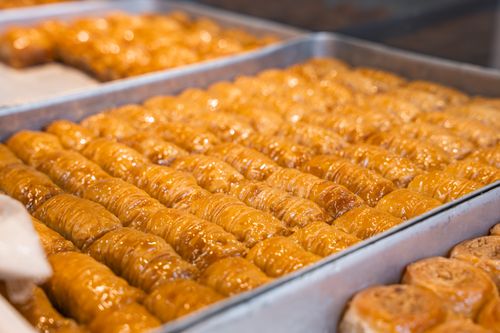 Free Rows of golden baklava in trays, showcasing fresh bakery goods. Stock Photo