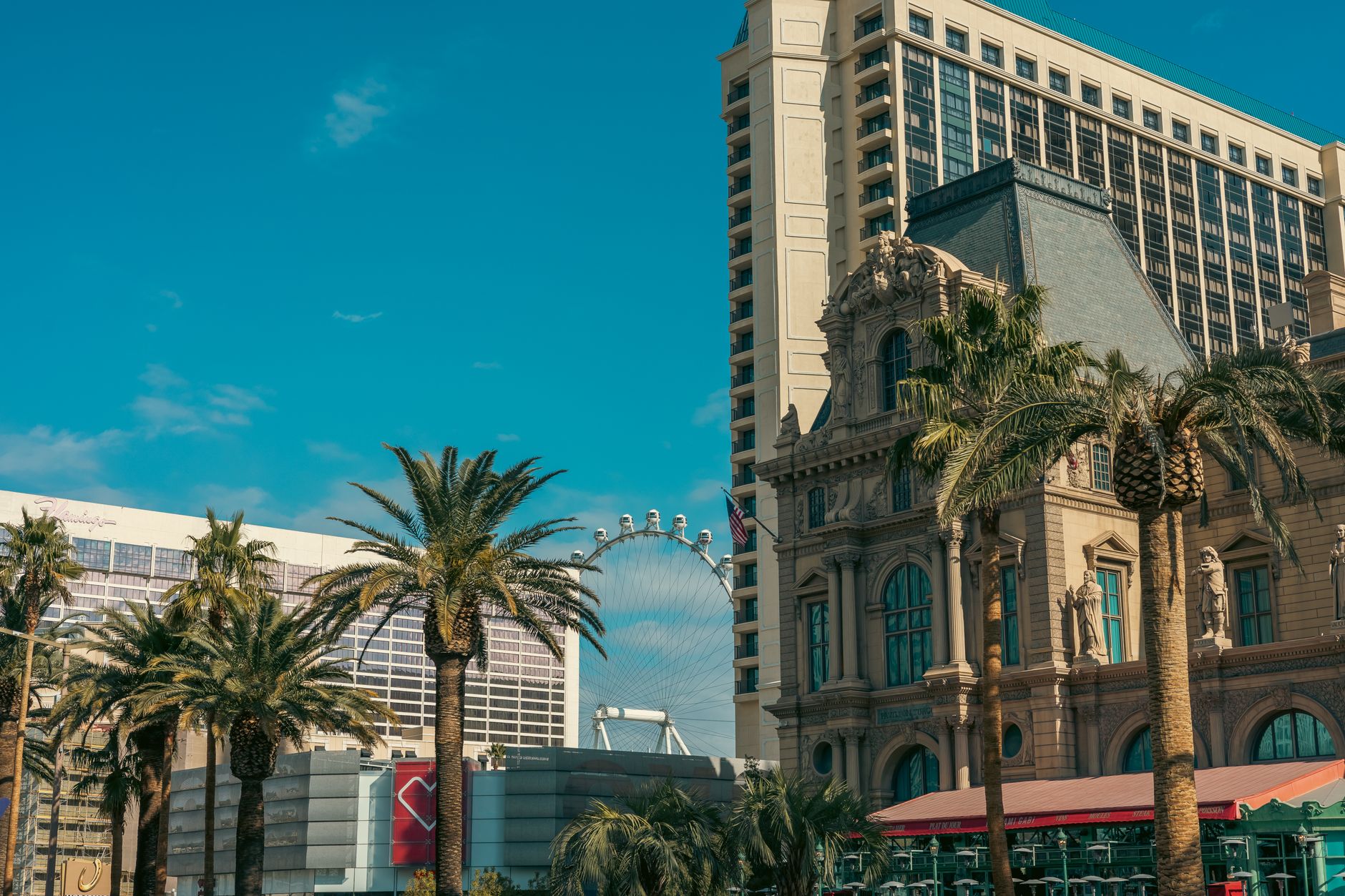 Vibrant Las Vegas cityscape featuring iconic buildings and the High Roller Ferris Wheel.