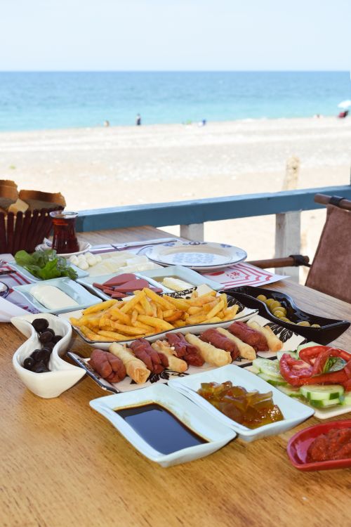 Free Enjoy a vibrant Turkish breakfast spread by the beach in Cide, Türkiye, featuring diverse and colorful dishes. Stock Photo
